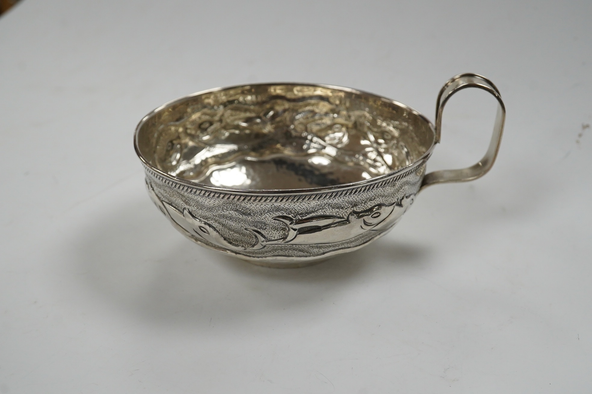 A Greek Lalaounis 800 standard white metal single handled cup, embossed with fish, diameter 11.5cm, 135 grams. Condition - fair